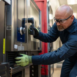 Service technician opening the door of a stainless steel commercial oven